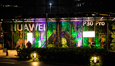 Vitrine Huawei iluminada com decoração de lançamento no PDV
